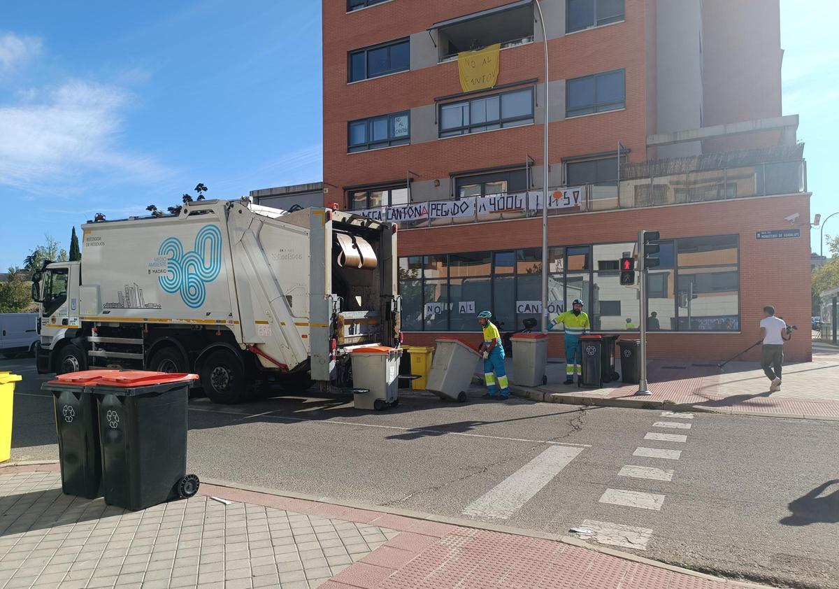 Un camión de basura para delante de varios mensajes contra el cantón de limpieza.