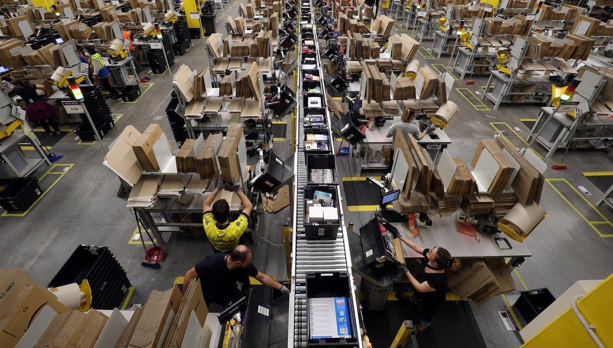 Workers process purchased orders at a packaging area inside Amazon distribution center in El Prat de Llobregat, near Barcelona, Spain, March 15, 2018. REUTERS/Albert Gea