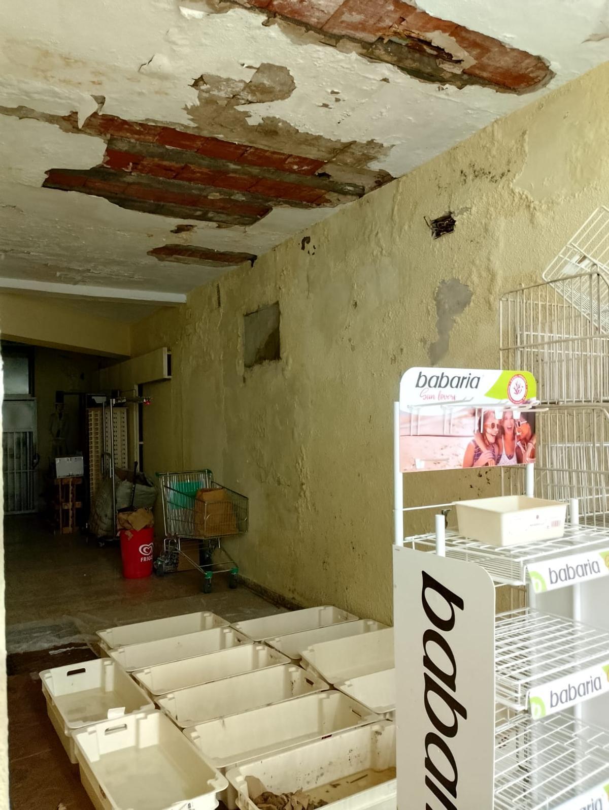 Uno de los bajos del inmueble, con desperfectos visibles.