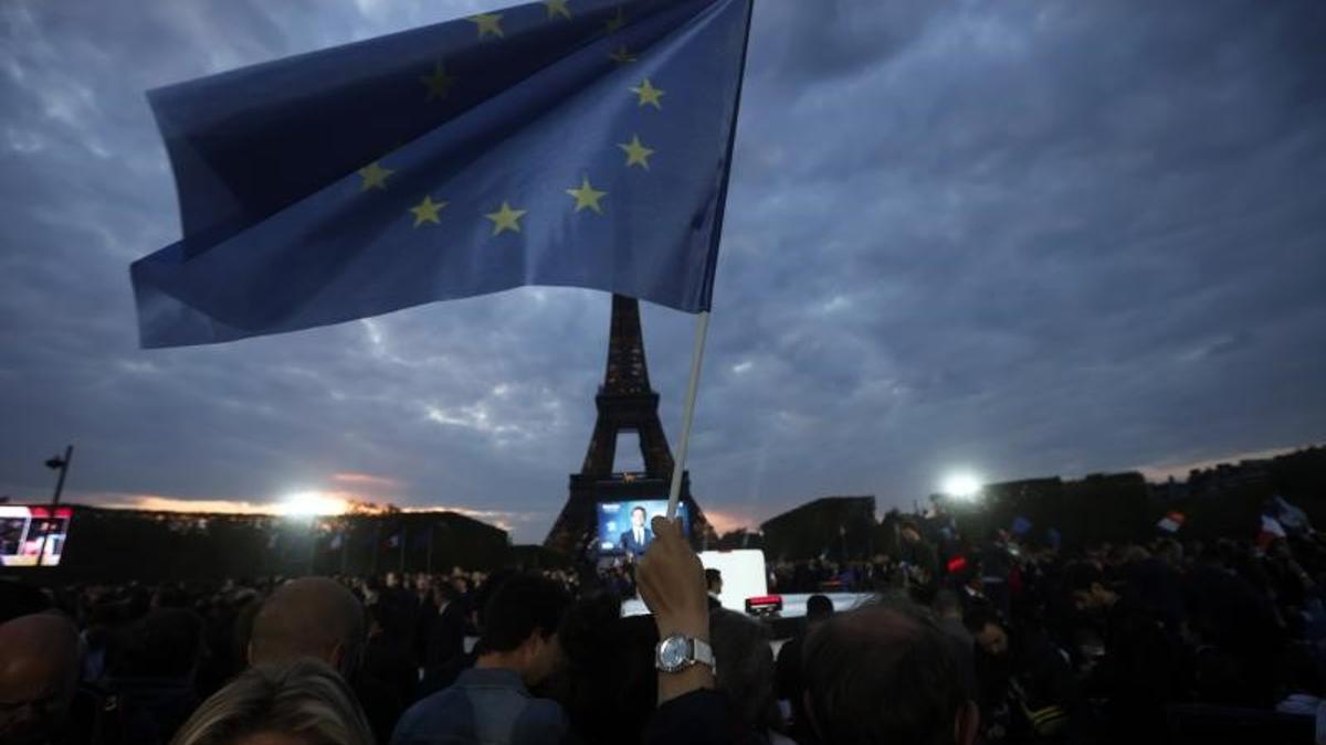 Simpatizantes del presidente francés, el reelegido Emmanuel Macron, celebran su victoria sobre Marine Le Pen en el Campo de Marte, a los pies de la Torre Eiffel, este 24 de abril de 2022, al cierre de la segunda vuelta de las presidenciales francesas.
