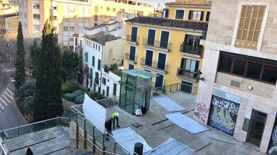 Los operarios proceden al cerramiento de la zona que ocupa el actual ascensor averiado.