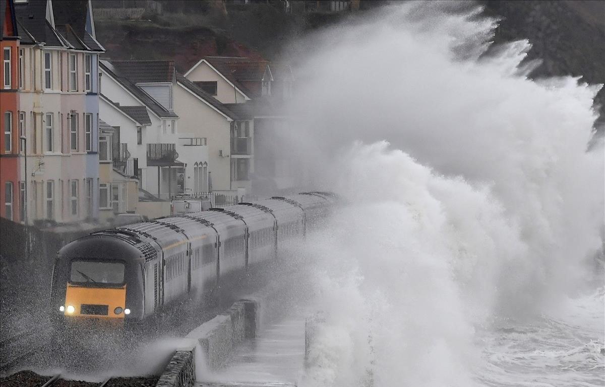 Grandes olas se estrellan contra un tren cuando pasa por Dawlish, en el suroeste de Gran Bretaña.