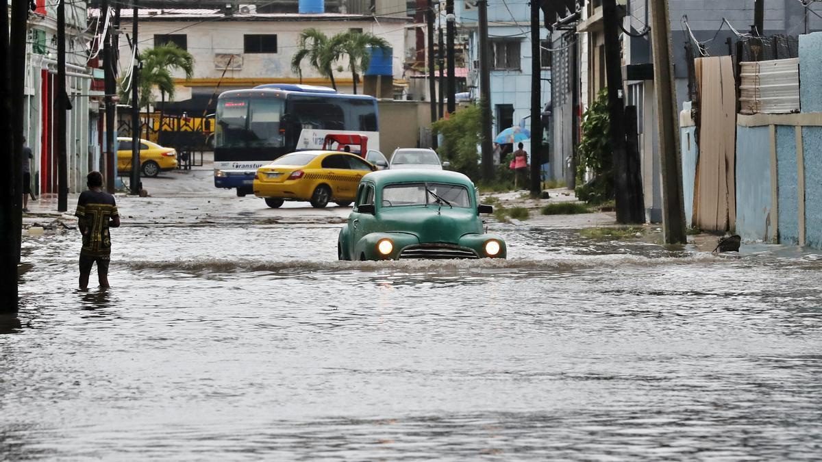 Vehículos transitan hoy por una calle inundada, en La Habana (Cuba). EFE/Ernesto Mastrascusa