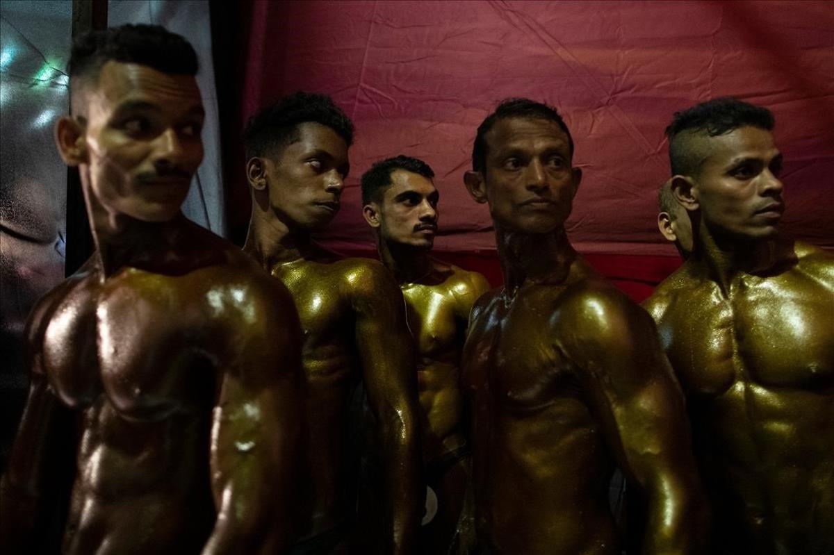 Culturistas esperan entre bastidores durante una competición en Mumbai, India.