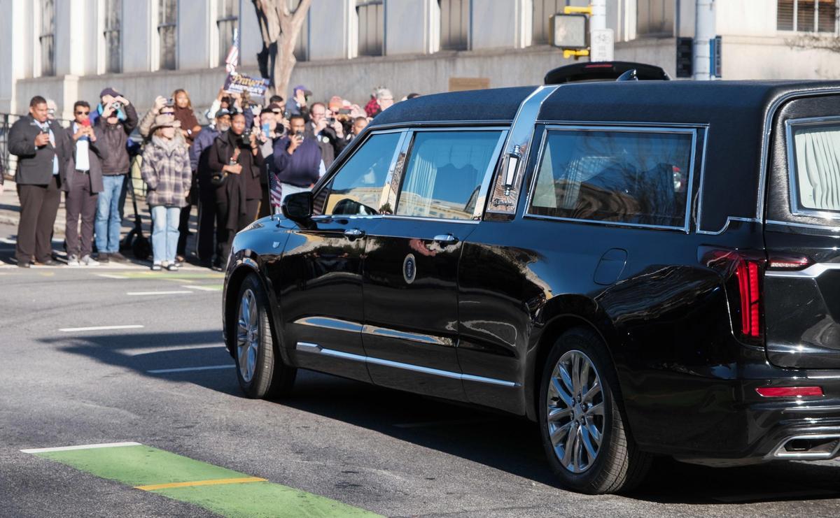 Un coche fúnebre que transporta el cuerpo del ex presidente Jimmy Carter parte tras su última visita al Capitolio de Georgia.