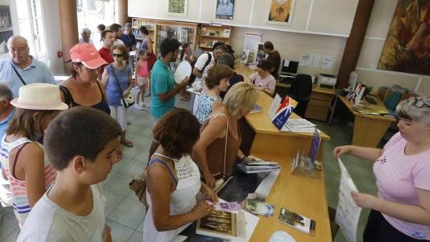 La Oficina de Turismo de Elche, llena de turistas e ilicitanos durante la primera quincena del mes de agosto, cuando se repartían libros de forma gratuita.