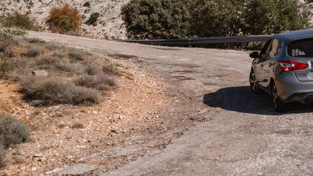 Un coche circula por la carretera llena de baches de Jadraque a La Toba.