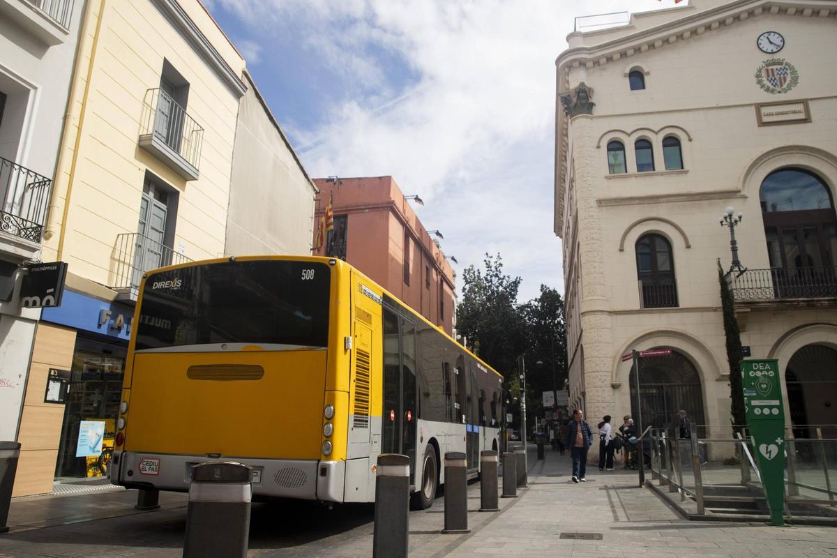 Un autobús circula por la calle Francesc Layret de Badalona, justo a su paso por la plaza de la Vila.