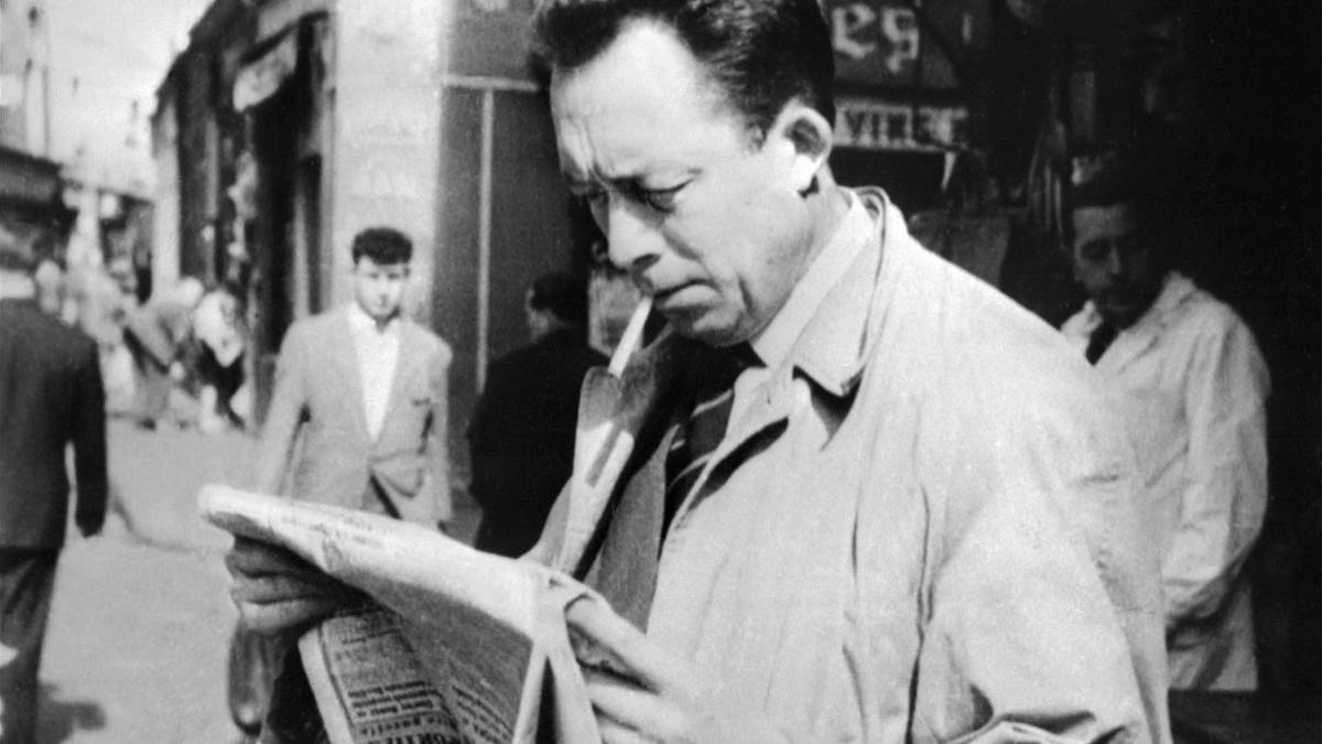 Albert Camus en 1959, leyendo el diario en las calles de París.