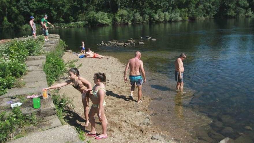 Bañistas ayer, remojándose en las orillas del Miño en Ourense. // Iñaki Osorio