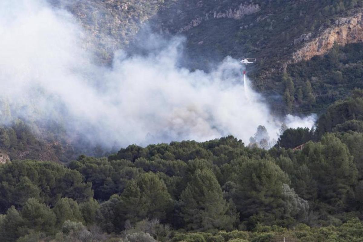 Un helicóptero realiza una descarga de agua en un incendio forestal junto el paraje la Murta en enero de 2024.