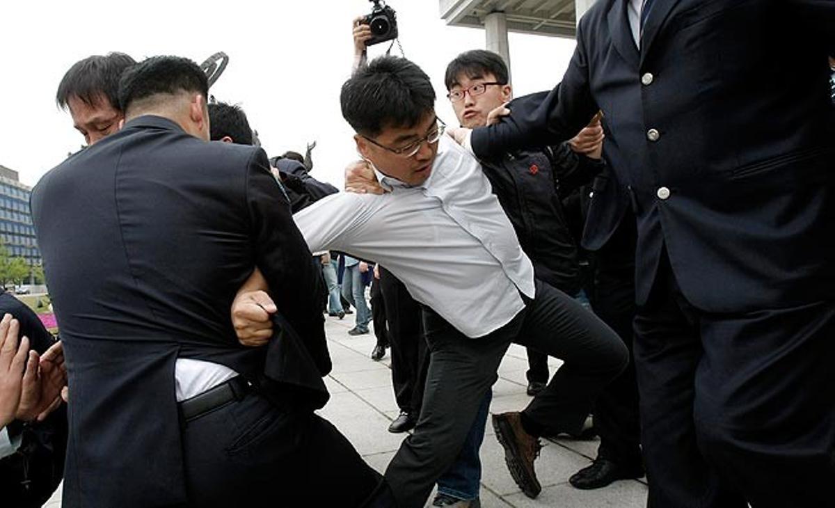 Un membre del Partit Socialista sud-coreà forceja amb uns policies després d’una manifestació en contra de l’acord de lliure comerç amb la Unió Europea que serà ratificat aquest dimecres.