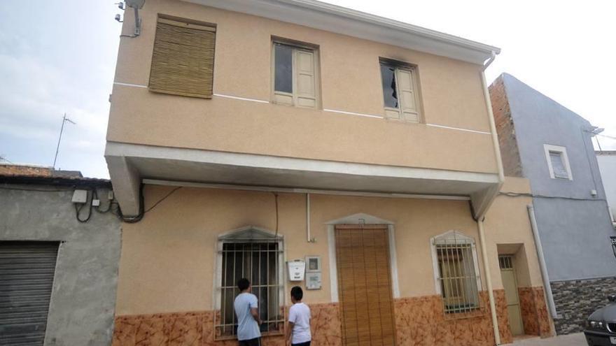 Unos niños, ayer en la puerta de la casa que ardió la semana pasada, en la calle Navarro de Ceutí.