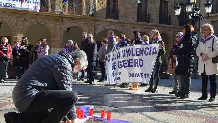 Un ciudadano enciende una vela por una de las víctimas mortales de este año, en el acto de la Plaza Mayor.