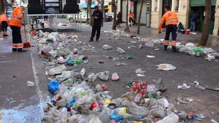 Un supervisor fotografía los residuos mientras trabajan varios barrenderos en la calle Conde Altea.