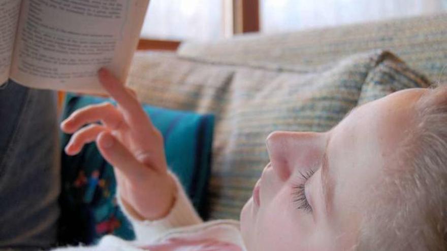 Una niña lee un libro.