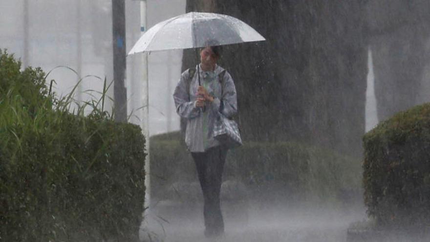 Una joven pasea bajo la lluvia en Kagoshima.