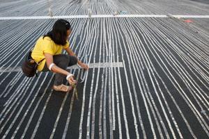 Una voluntària participa en l’intent d’aconseguir un rècord Guiness alineant el màxim de monedes en un parc de Manila (Filipines).