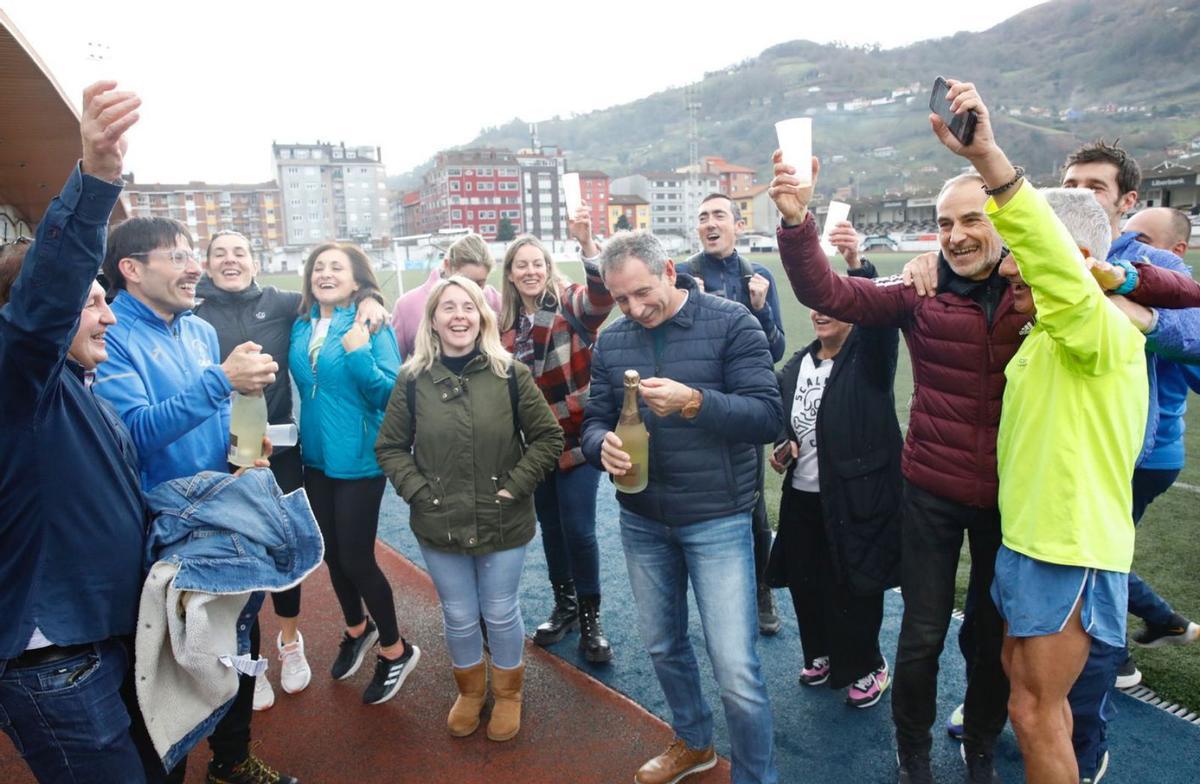 Integrantes del Club Atletismo Mieres, el año pasado, celebrando el Gordo, con Jesús Hevia en el centro descorchando una botella de champán. | LNE