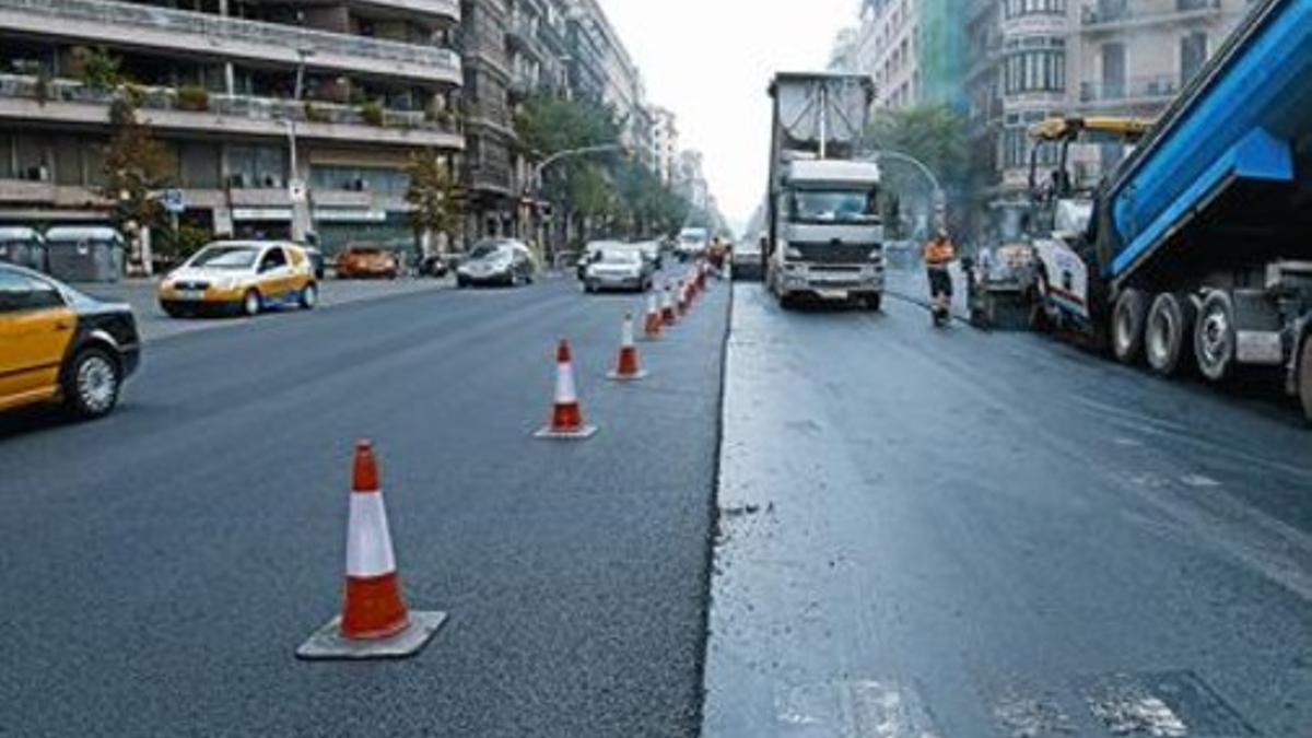 Unos obreros realizan obras de asfaltado en un tramo de la avenida Diagonal y, a la derecha, imagen del volcado de asfalto en un tramo de la calle de Aragó, ayer.