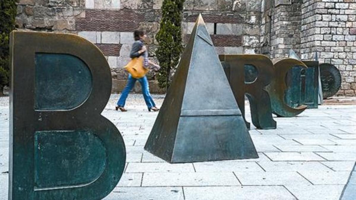 Legado  Las letras de Barcino, en la plaza Nova, y el antifaz dorado que Brossa diseñó para los premios FAD Sebastià Gasch en el suelo de la Rambla, a la altura de Carme.