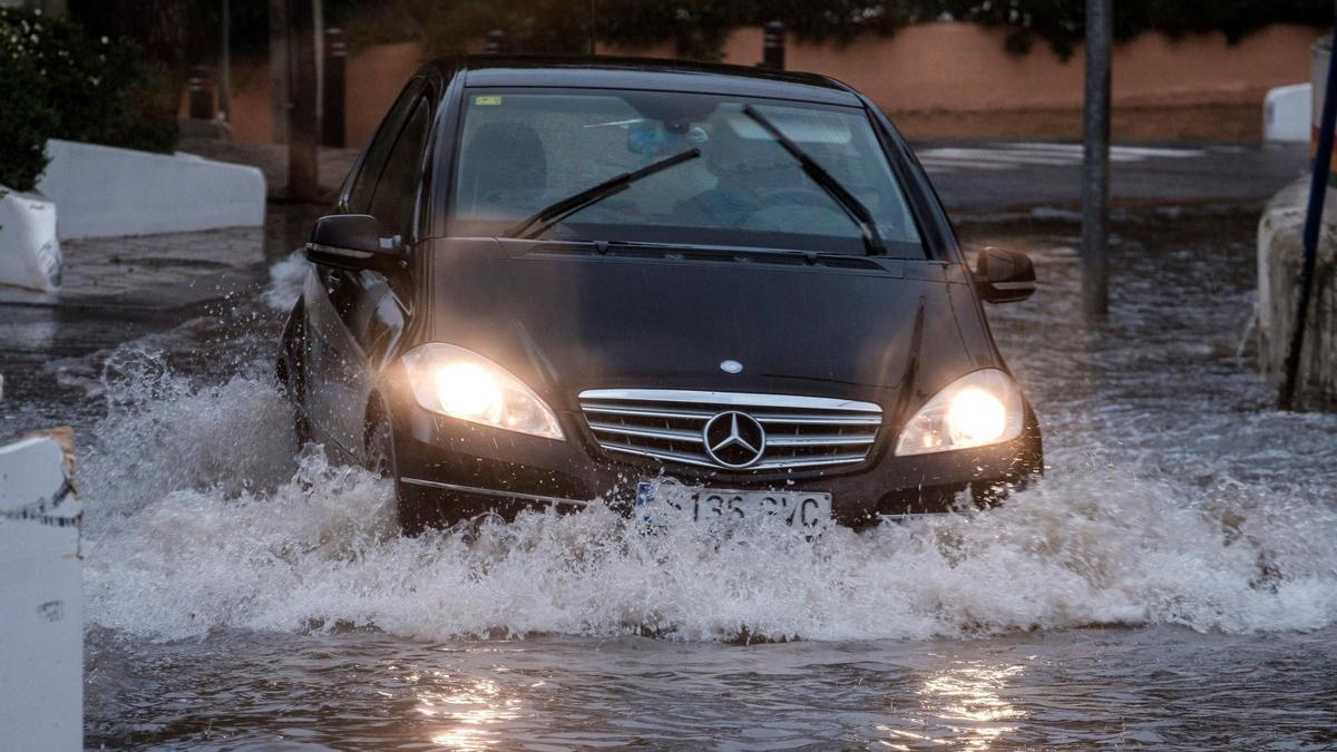 Un coche transita una calle inundada de Cala de Bou (Ibiza).