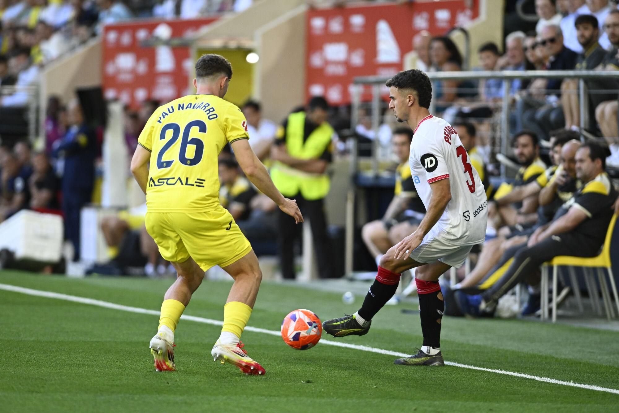 VILLARREAL (CASTELLÓN), 25/05/2025.- El defensa del Villarreal Pau Navarro (i) pelea un balón ante el defensa del Sevilla Adrià Pedrosa este domingo, durante el partido de la jornada 38 de LaLiga EA Sports, que Villarreal y Sevilla disputan en el Estadio de la Cerámica. EFE/ Andreu Esteban