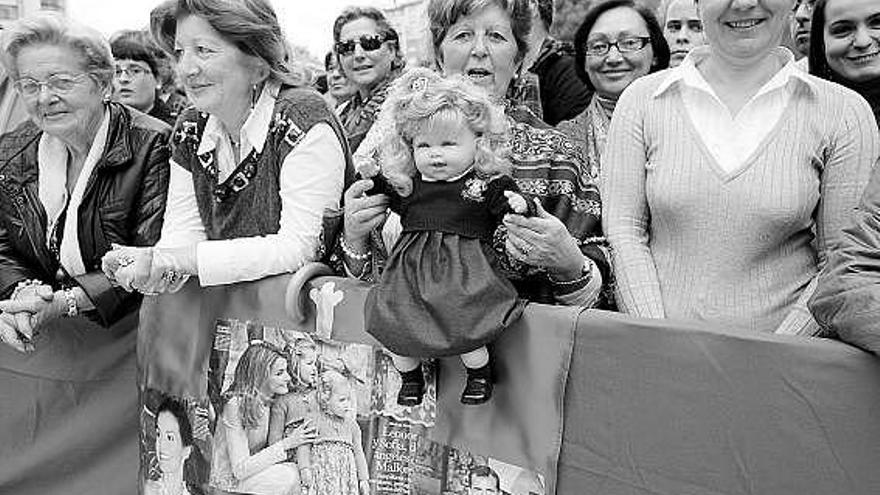 Parte del público, con una muñeca de la Infanta Leonor, fotografías de los Príncipes y una bandera de Asturias.