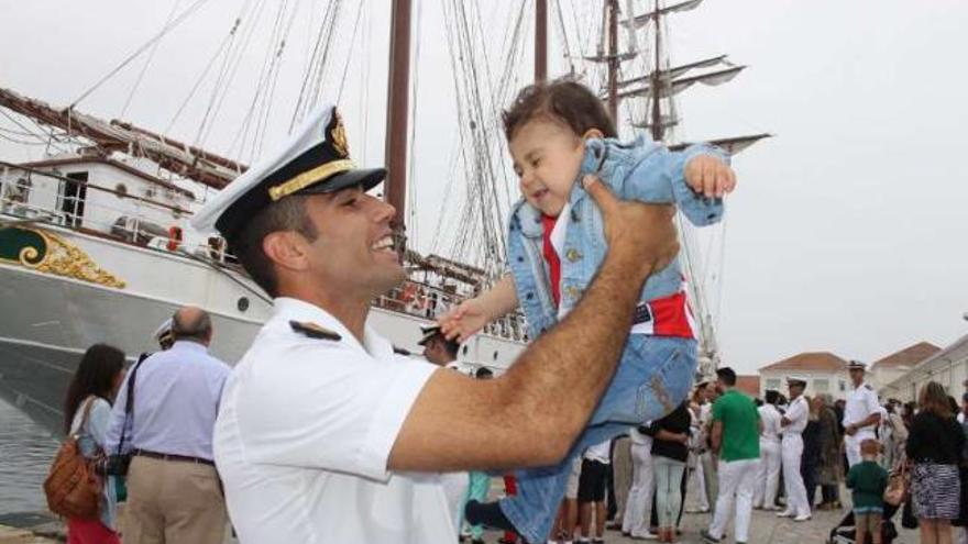 Un miembro de la tripulación  de &quot;Elcano&quot; juega con su hijo en el muelle de la Escuela Naval Militar de Marín. // Santos Álvarez