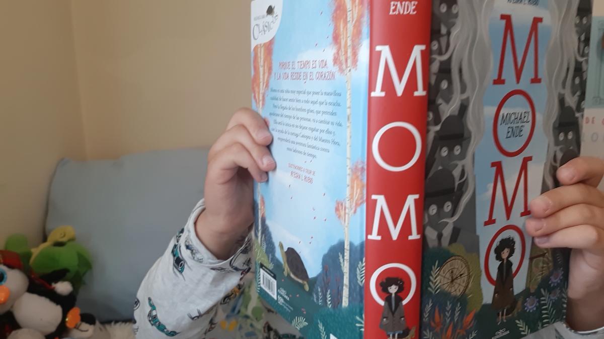 Un niño lee 'Momo' en su habitación.