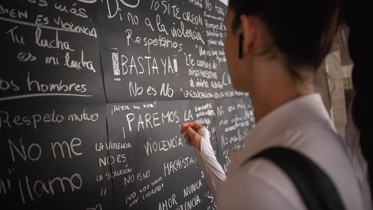 Una estudiante de la ULL escribe su frase contra la violencia machista en la Facultad de Medicina.