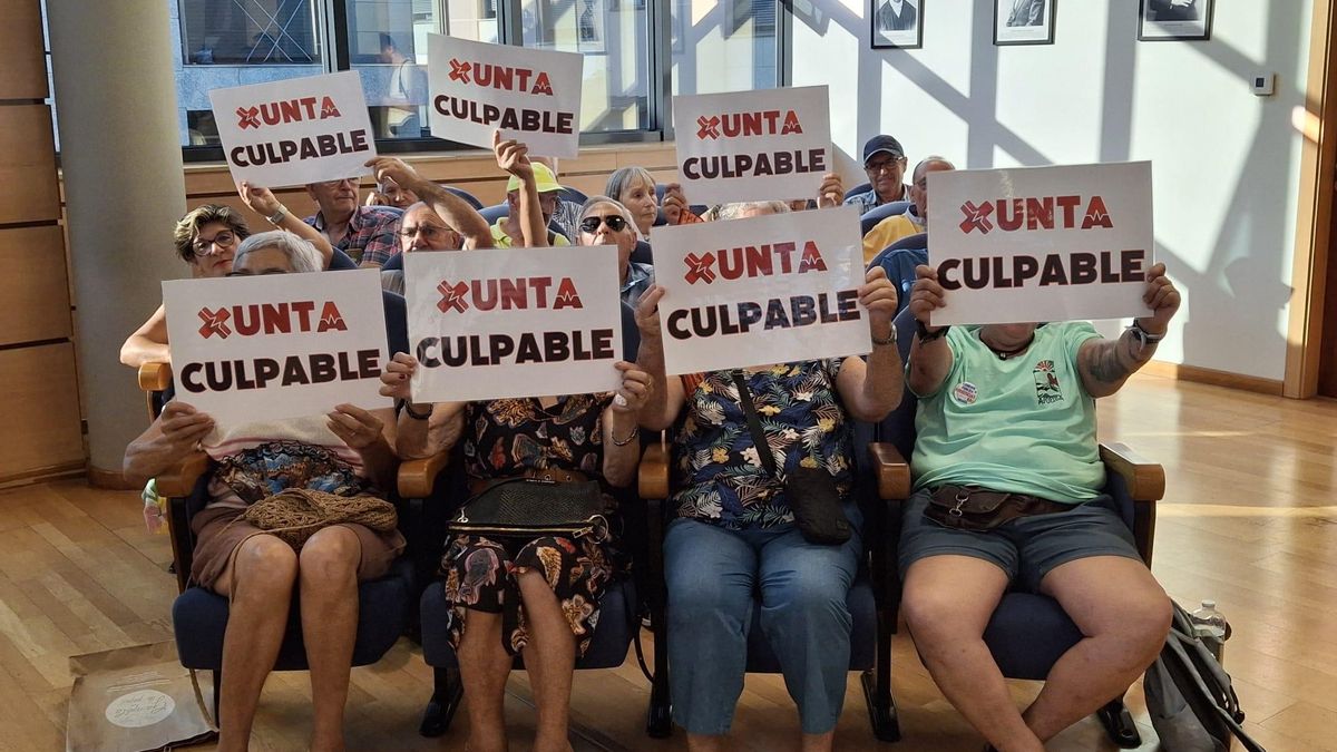 Vecinos en el pleno con pancartas de protesta contra la Xunta por la falta de urgencias.