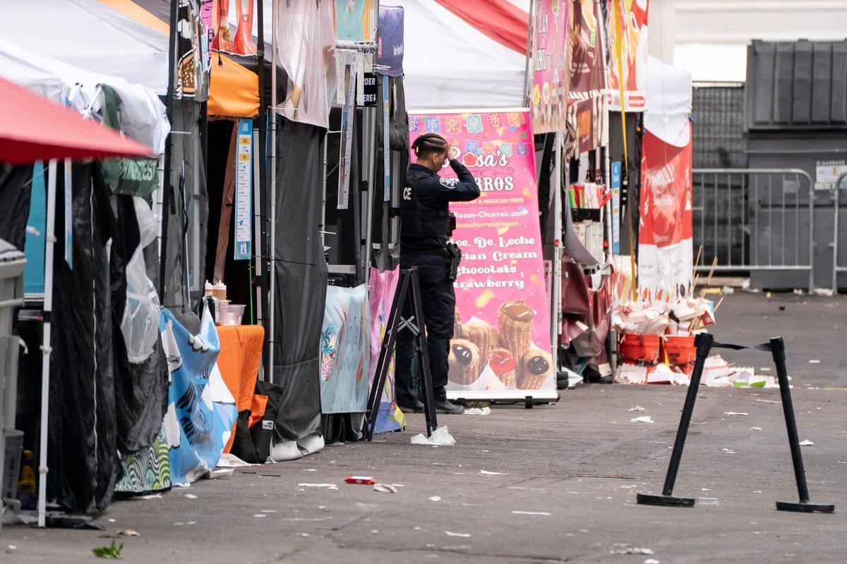Un agente de policía permanece junto a los puestos abandonados del festival gastronómico Bite of Seattle Un agente de policía permanece junto a los puestos abandonados del festival gastronómico Bite of Seattle