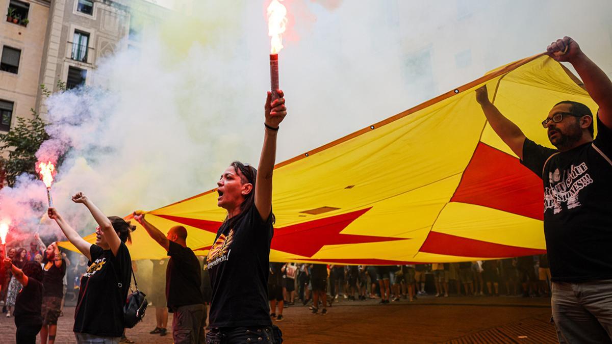 Diverses persones sostenen una estelada i unes bengales amb fum amb motiu de la Diada de lOnze de Setembre