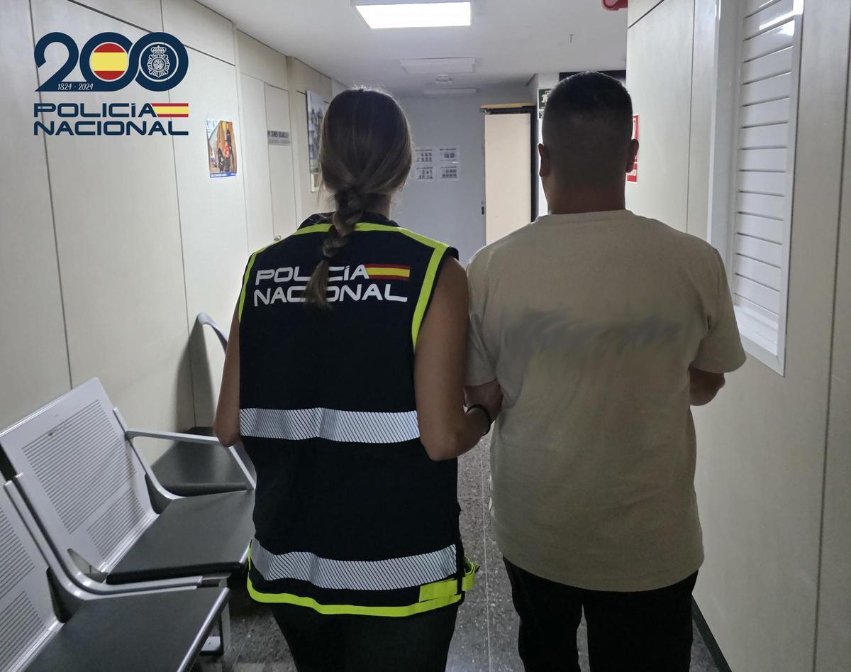 Una policía nacional lleva detendio a uno de los presuntos atracadores de la vivienda de Son Puig.