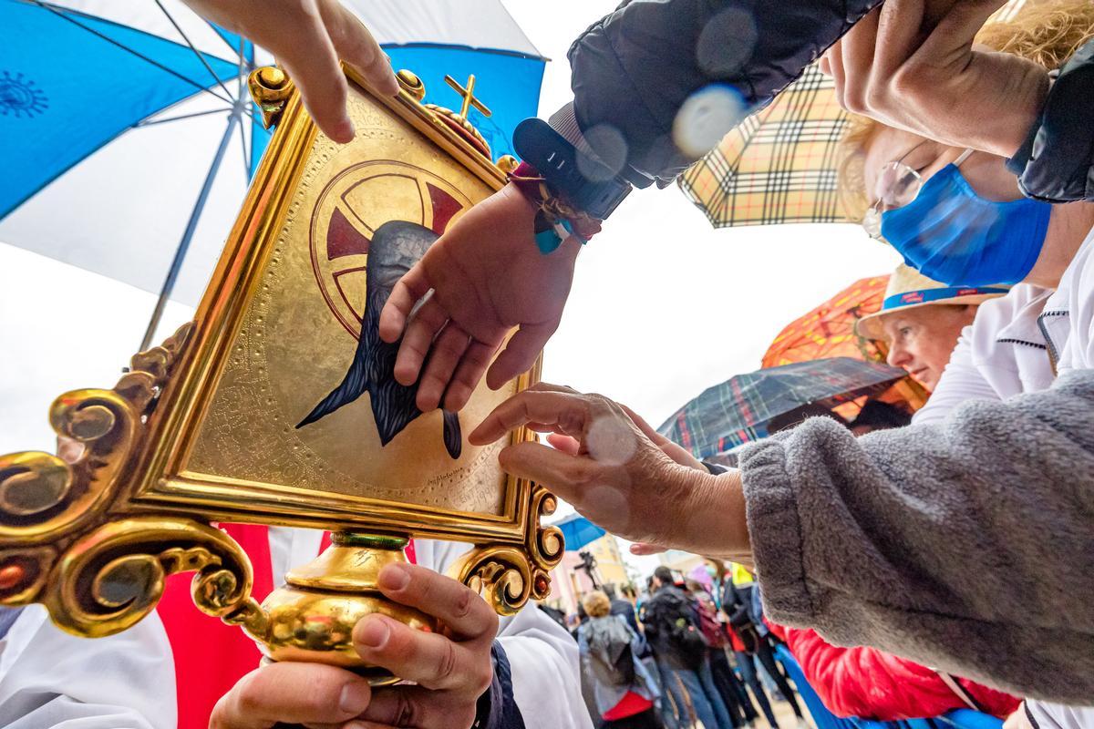 Varias personas tratan de tocar la imagen de la Santa Faz en la romería de 2022.