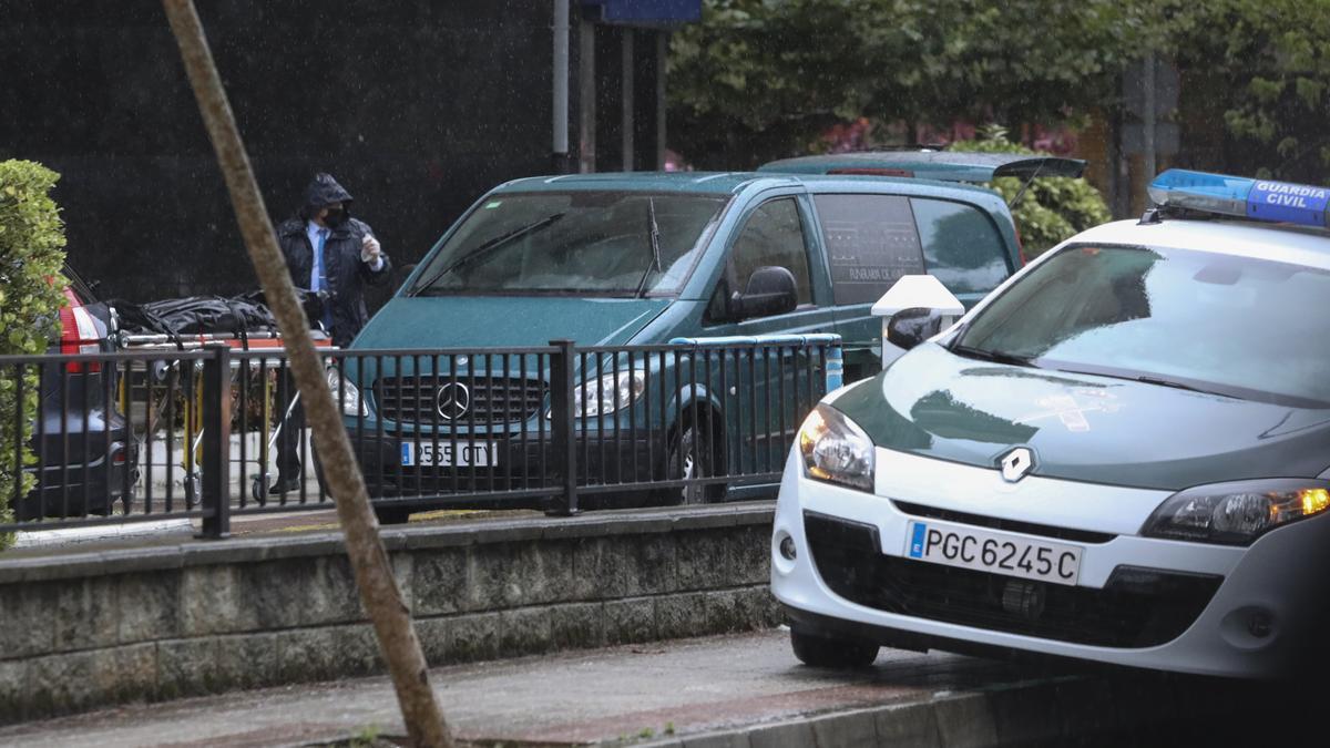 Empleados de la funeraria retiran el cadáver de la mujer que supuestamente se precipitó por una ventana.