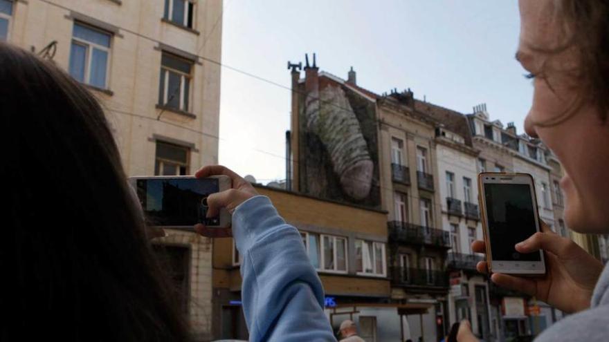 Dos jóvenes fotografían el peculiar arte urbano.