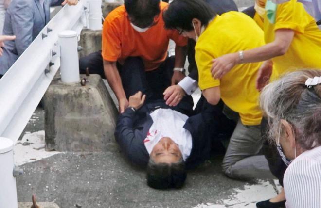 This screen grab shows former Japanese Prime Minister Shinzo Abe lies on the ground after he was shot from behind by a man during an election campaign for the July 10, 2022 Upper House election in Nara