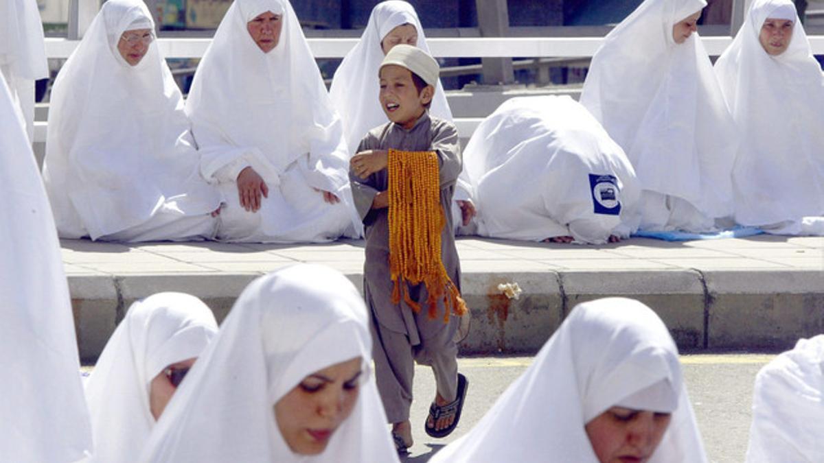 Un niño ofrece cuentas para rezar a peregrinas en la Meca.