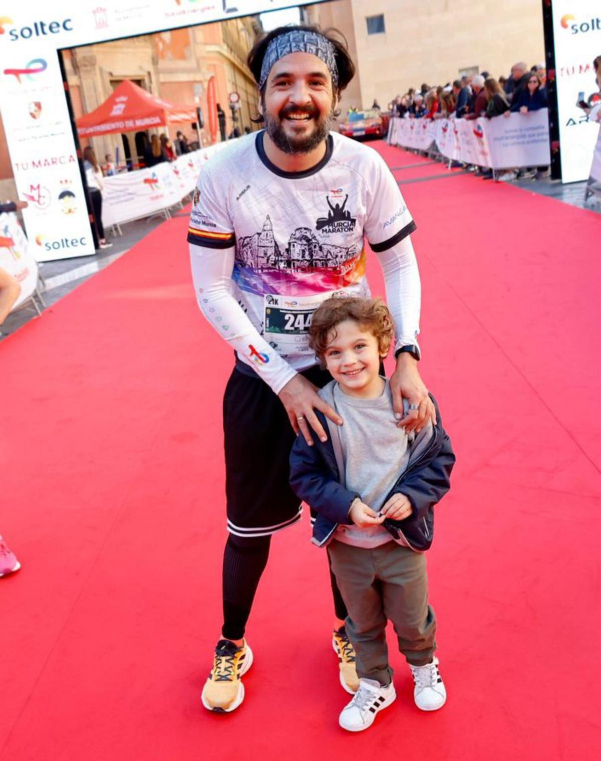 Jona Lorenzo con su hijo Darío (izquierda) y un participante entra descalzo en meta. | JUAN CARLOS CAVAL