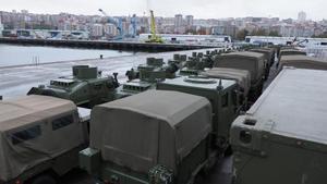 Camiones, vehículos de combate y ambulancias militares en el muelle comercial.