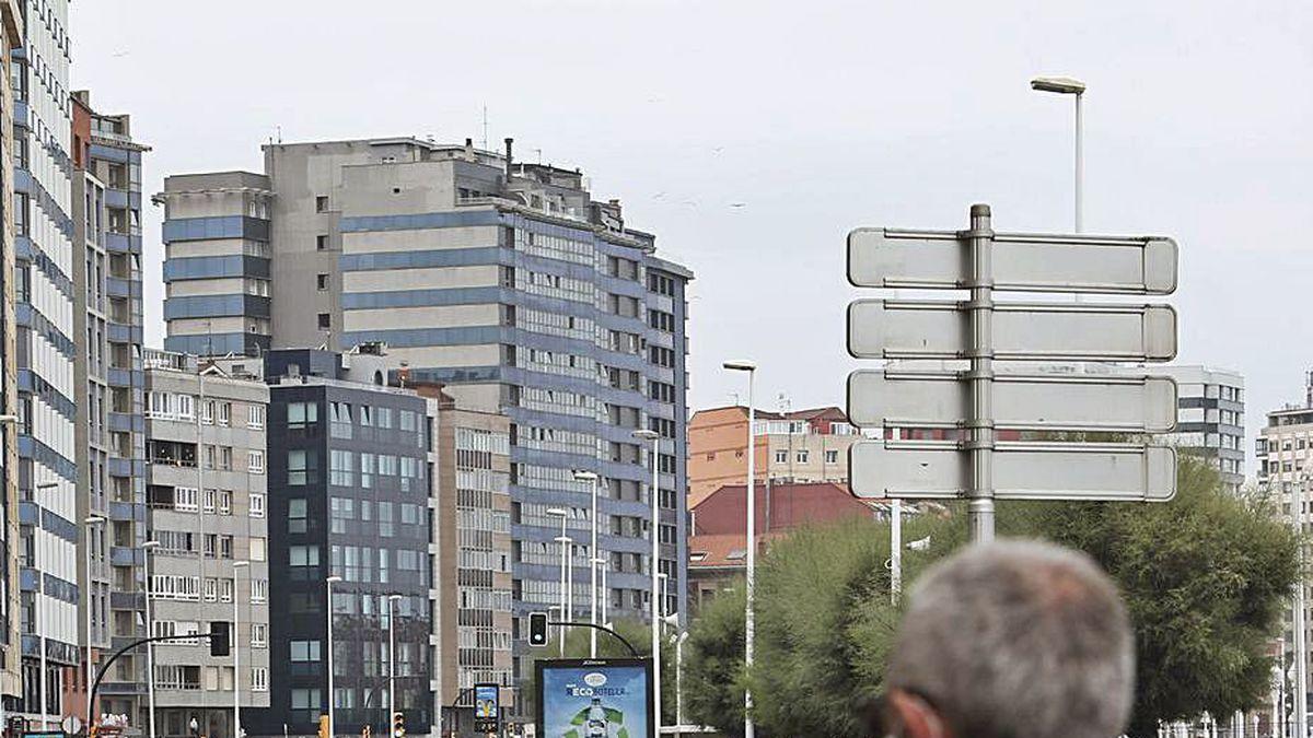 Unos viandantes observan los separadores que marcan el nuevo carril bici del Muro.