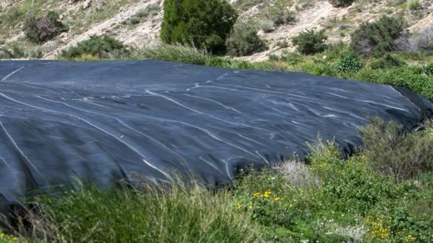 El paisaje negro predomina en el entorno del pantano de Elche.