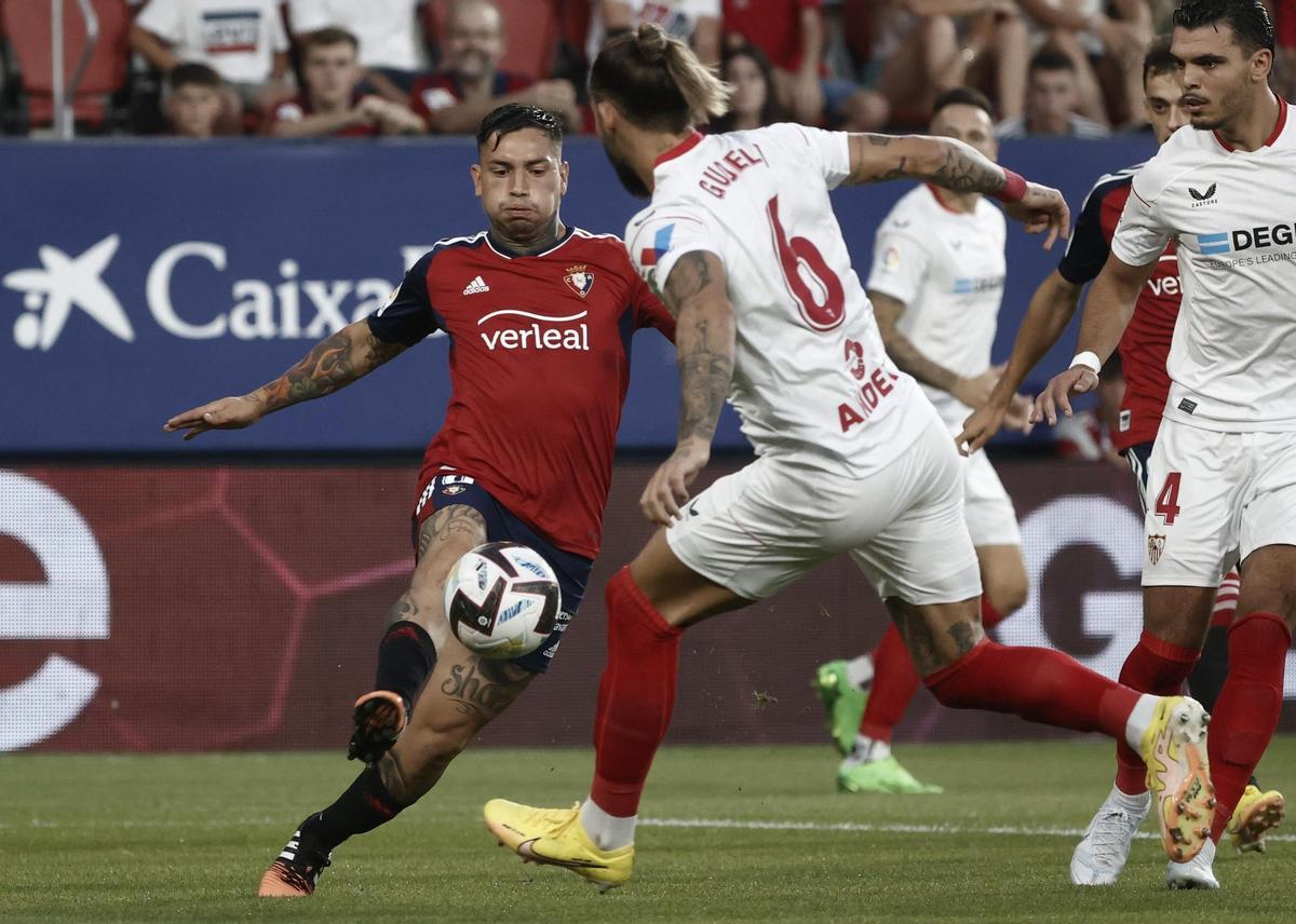 PAMPLONA, 12/08/2022.- El delantero argentino de Osasuna Ezequiel Ávila (i) lucha con el serbio Nemanja Gudelj, del Sevilla FC, durante el encuentro correspondiente a la primera jornada de LaLiga entre CA Osasuna y Sevilla FC, este viernes en el estadio de El Sadar, en Pamplona. EFE/ Jesús Diges