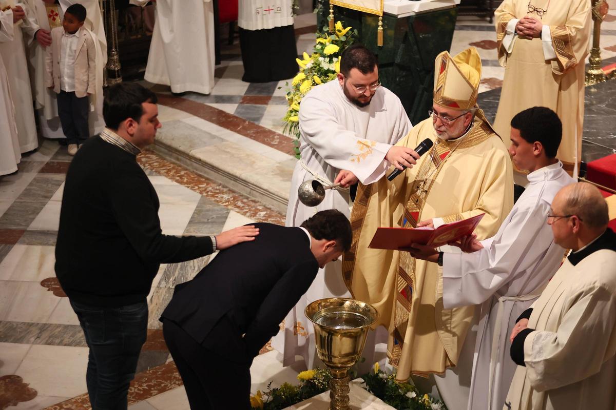 El Arzobispo bautiza a uno de los veintidos adultos que recibieron el sacramento este domingo.