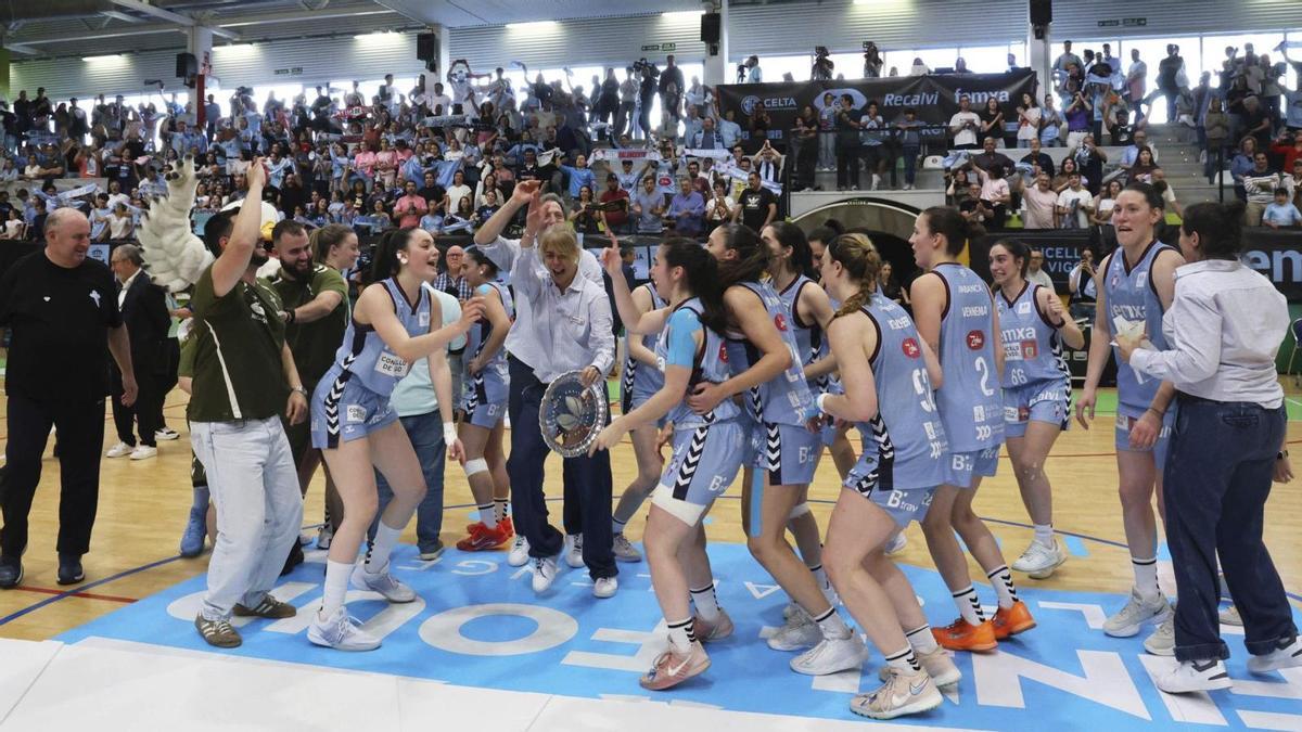 Cantero sostiene el trofeo de campeón de la final a cuatro en medio de la fiesta de la plantilla en Navia. | ALBA VILLAR