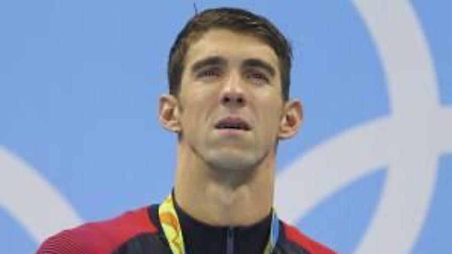 Michael Phelps emocionado en el podio.