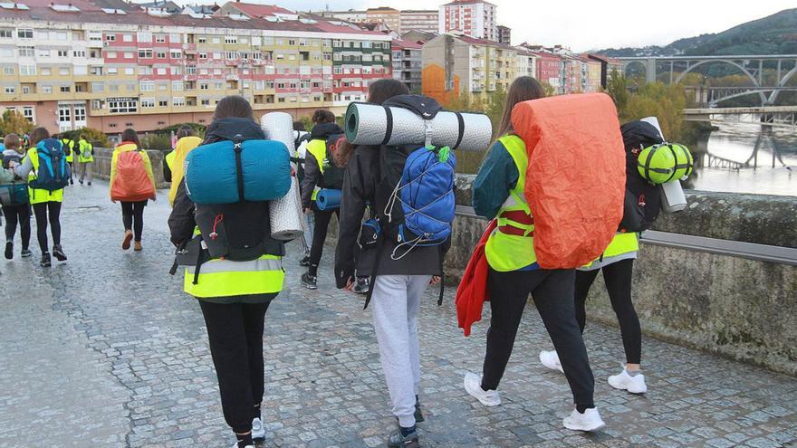 Un grupo de peregrinos cruza el Puente Romano.