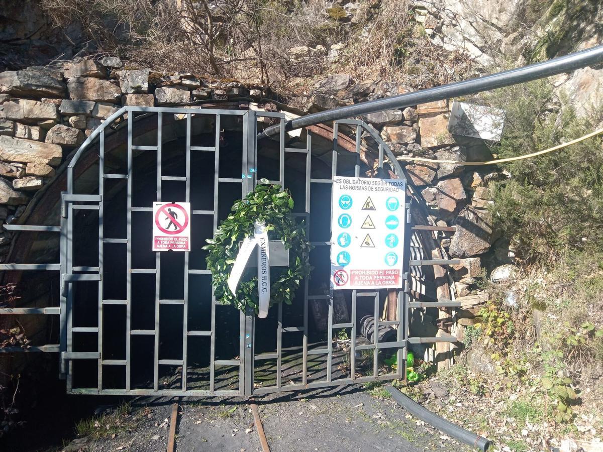Una corona puesta por exmineros a la entrada de la mina de Cerredo.